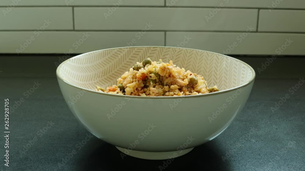 Hot shredded cauliflower rice dish poured into a bowl - A healthy lunch for your low calories diet Hot shredded cauliflower rice dish poured into a bowl - A healthy lunch for your low calories diet