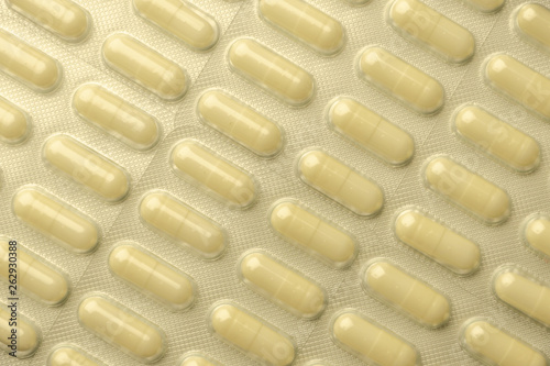 many pills laid out in rows, for background, low contrast, haze