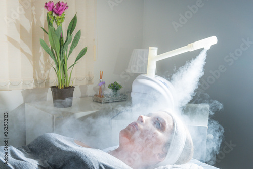 Beauty treatment of face with ozone facial steamer in beauty center. Beaultiful Blonde Girl.