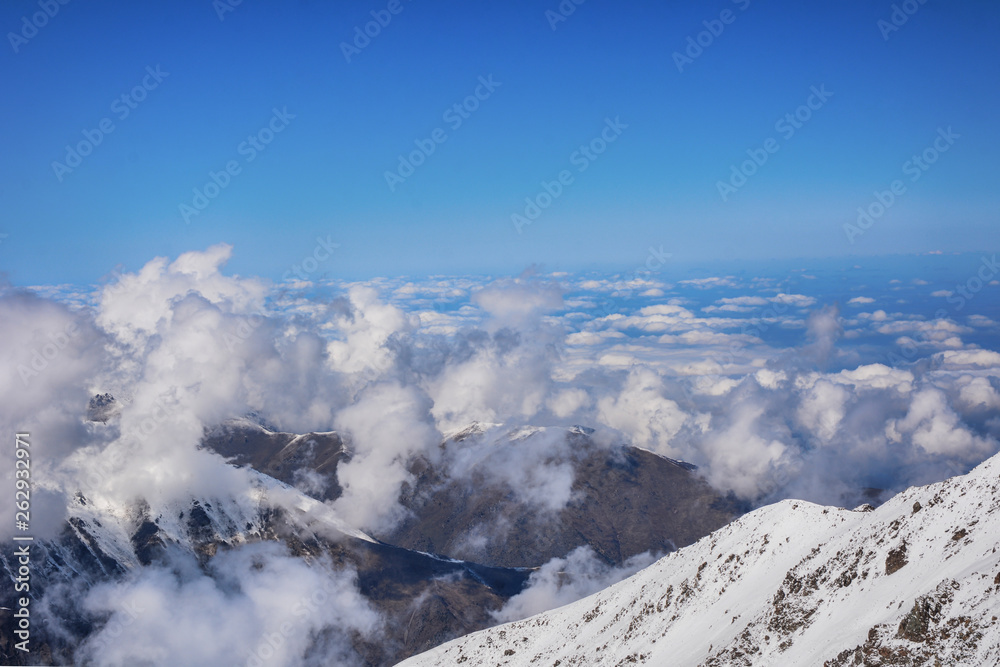 Beautiful view above the clouds over mountains and valley.