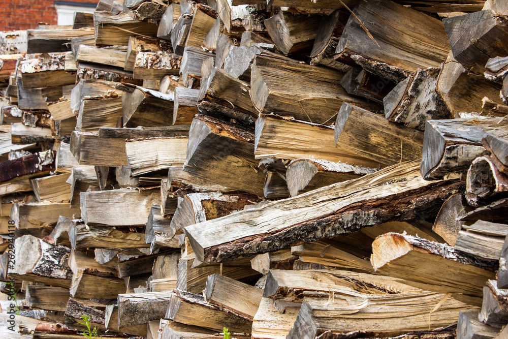 A wall of logs stacked on top of each other, a full yard with a pile of firewood, wooden beams. Wooden natural texture. Island Suomenlinna in Helsinki, Finland. A wall of logs stacked on top of each other, a full yard with a pile of firewood, wooden beams. Wooden natural texture. Island Suomenlinna in Helsinki, Finland.