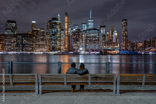 Obraz na płótnie Scene of back side couple sitting and looking New york Cityscape beside the east