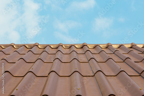 Roof house with tiled roof on blue sky.