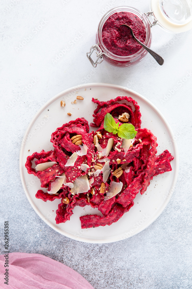 Top view of vegetarian mafaldine pasta with beet pesto sauce, walnut and parmesan cheese on a white background Top view of vegetarian mafaldine pasta with beet pesto sauce, walnut and parmesan cheese on a white background