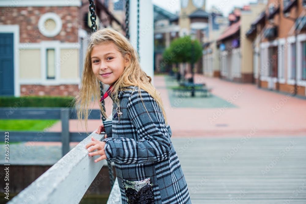 Little fashionable girl in warm clothes walk outdoor, Autumn - Winter season, holidays and children concept. Sweet girl at European street Little fashionable girl in warm clothes walk outdoor, Autumn - Winter season, holidays and children concept. Sweet girl at European street