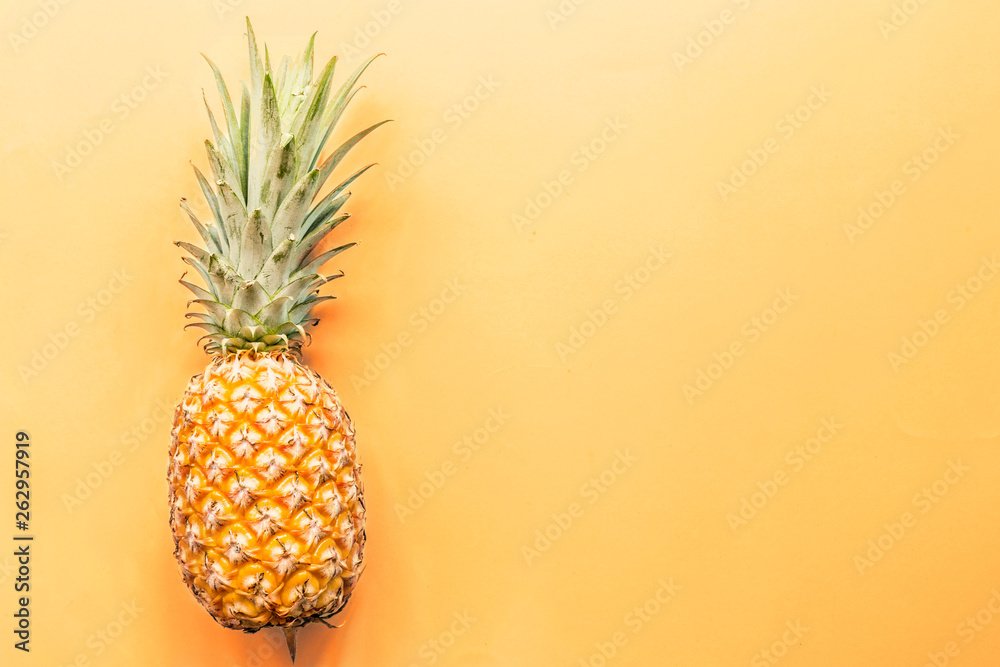 Fresh pineapple lying on orange background. Top view. Flat lay concept. Place for text