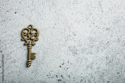 Old key on old gray concrete background. Copy space, top view. © Iryna Melnyk