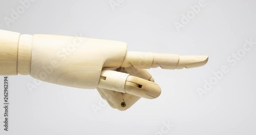 Finger of wooden hand figure point on the white background isolated shot. Stop motion, animation. 