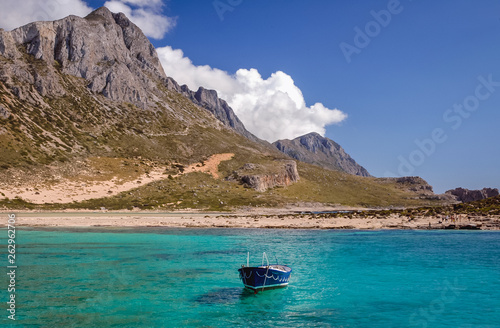 Small boat on a shore of Balos beach on a lagoon between Tigani Rock and coast of Crete Island, Greece