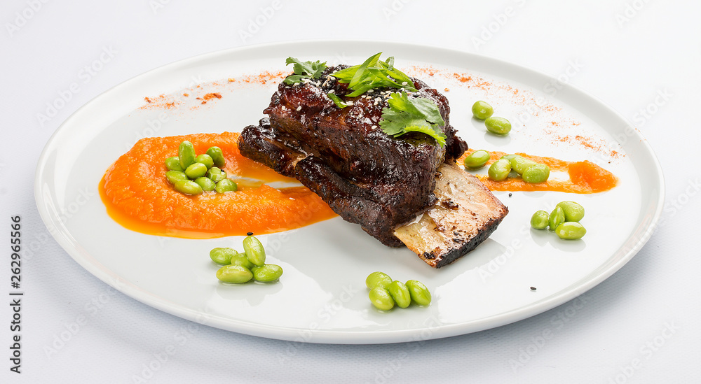 Pork rib with sauce on a white plate