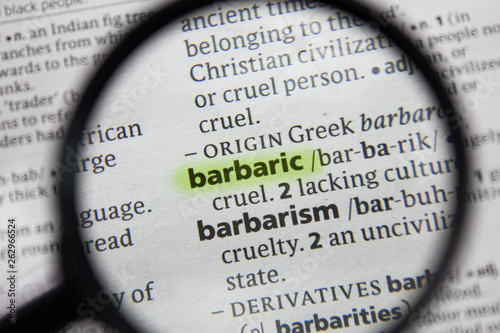 The word or phrase barbaric in a dictionary. photo