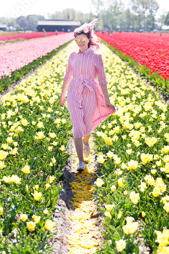 Smiling teenage girl walks through tulip field