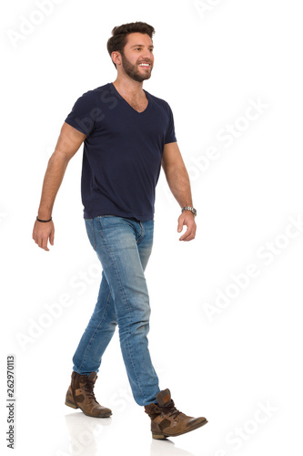Happy Walking Man In Blue T-shirt, Jeans And Boots Looking Away