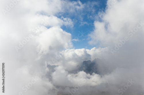 Big clouds in a sunny day from a mountain peak in Dolomites