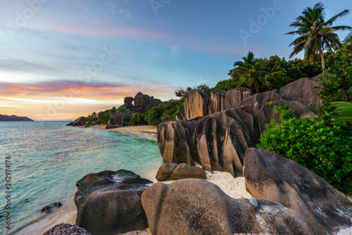 sunset over rocks,sand,palms,turquoise water at tropical beach,la dique,seychelles paradise 1