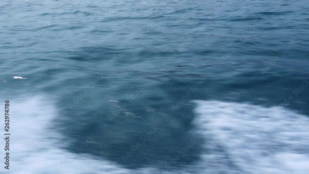 Water trail on blue sea surface from floating ship close up. Trail turquoise sea water with foam and waves, spills, bubbles, traces from sailing boat. Water trail on blue sea surface from floating ship close up. Trail turquoise sea water with foam and waves, spills, bubbles, traces from sailing boat.