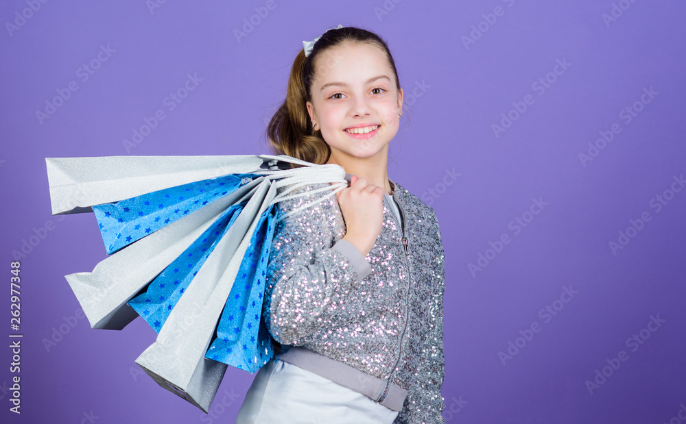 Shopping day. Child hold bunch packages. Kids fashion. Birthday girl. Favorite brands and hottest trends. Girl with shopping bags violet background. Shopping and purchase. Black friday. Sale discount Shopping day. Child hold bunch packages. Kids fashion. Birthday girl. Favorite brands and hottest trends. Girl with shopping bags violet background. Shopping and purchase. Black friday. Sale discount