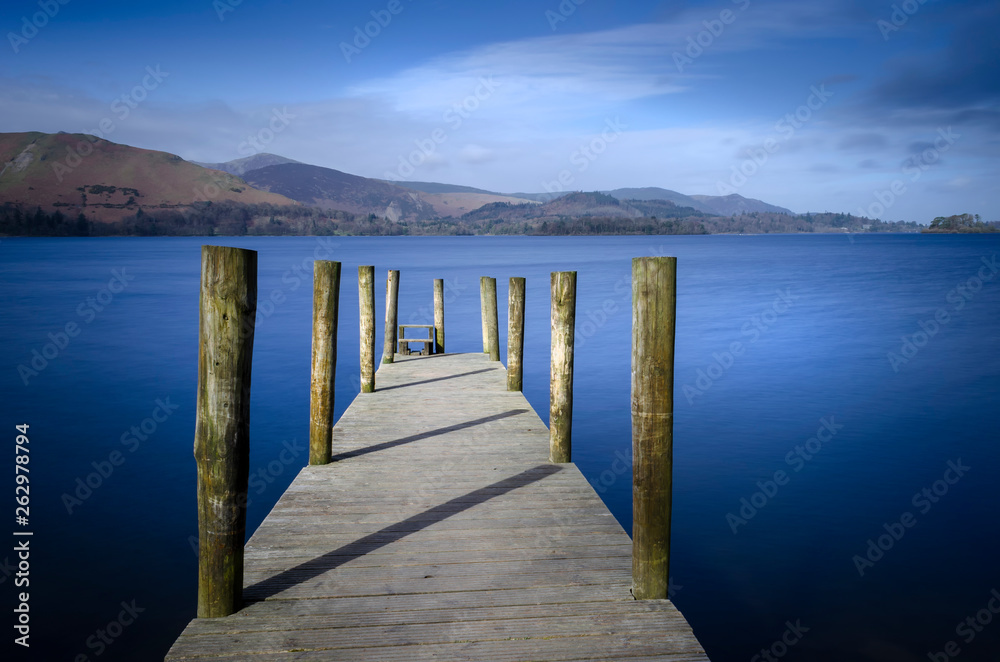Obraz premium Ashness Bridge jetty on Derwentwater in the Lake district National park England showing a calm Lake and blue sky. 
