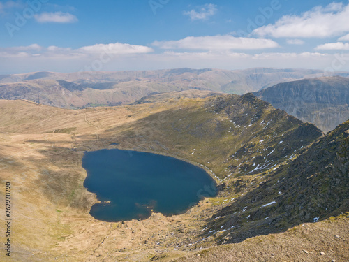 Red Tarn, a small lake on the eastern flank of Helvellyn, beneath Striding Edge and Catstye Cam in the Lake District in Cumbria, England, UK