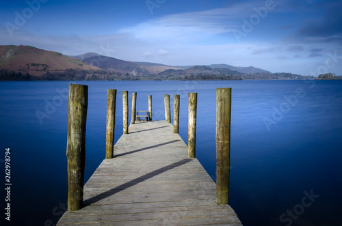 Ashness Bridge jetty on Derwentwater in the Lake district National park England showing a calm Lake and blue sky. 