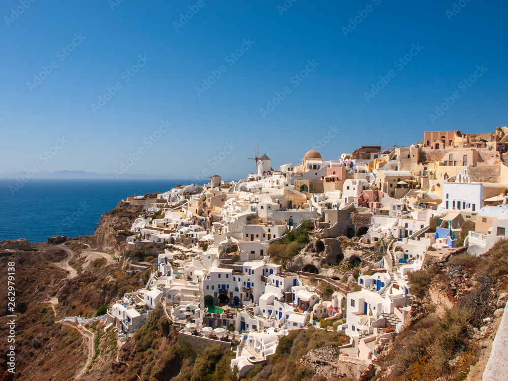 Oia village on the island of Santorini Greece is well known for its collection of white washed terraced apartments climbing up the side of the rock face.  