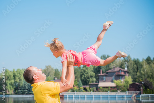 Healthy loving father and daughter playing together at the beach on vacation. Happy fun smiling lifestyle, fathers day. Dad and child daughter playing together outdoors 