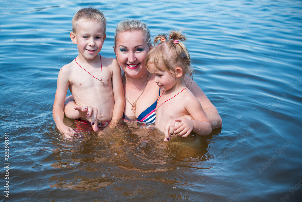 Mom with two children walking outdoor, warm weather. Lifestyle portrait mom and kids in happiness at the outside, vacation moments Mom with two children walking outdoor, warm weather. Lifestyle portrait mom and kids in happiness at the outside, vacation moments