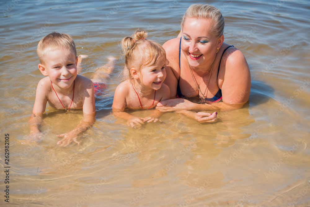 Mom with two children walking outdoor, warm weather. Lifestyle portrait mom and kids in happiness at the outside, vacation moments Mom with two children walking outdoor, warm weather. Lifestyle portrait mom and kids in happiness at the outside, vacation moments