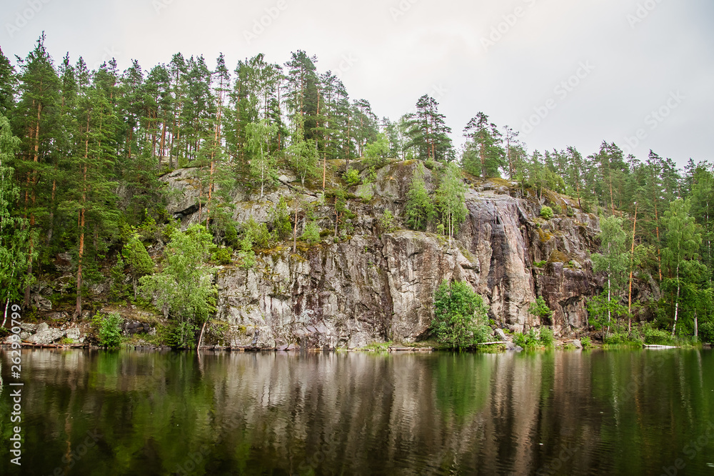 calm lake with reflection of the rock on the shore