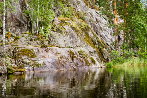 primal rocky shore of a calm lake in Karelia