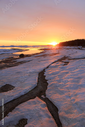 Snow and ice on north sea at sunset