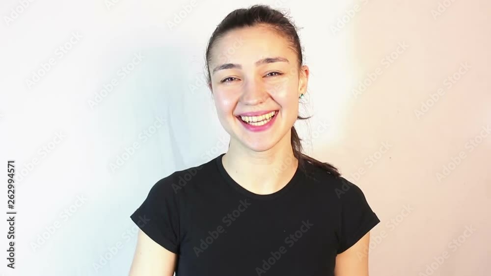 Young beautiful girl smiles broadly and waving her arms in greeting.Portrait on a white background. Young beautiful girl smiles broadly and waving her arms in greeting.Portrait on a white background.