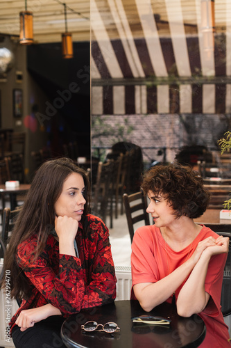Friends hanging out at a coffee shop. Two girls chilling in a restaurant.