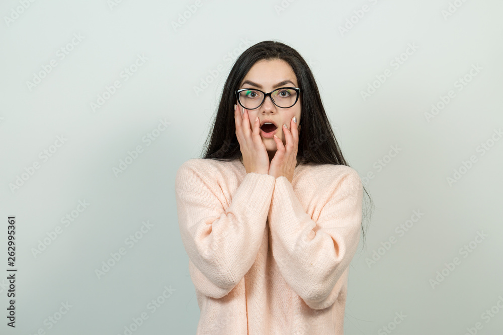 Emotional portrait of a dark-haired girl on a gray background, stormy emotions, business concept. Emotional portrait of a dark-haired girl on a gray background, stormy emotions, business concept.