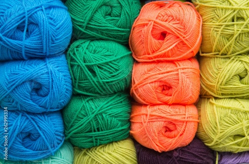 Multi-colored yarn. Yarn is beige, brown, grey and white. Knitting needles, scissors, coffee, knitting, knitted fabric.