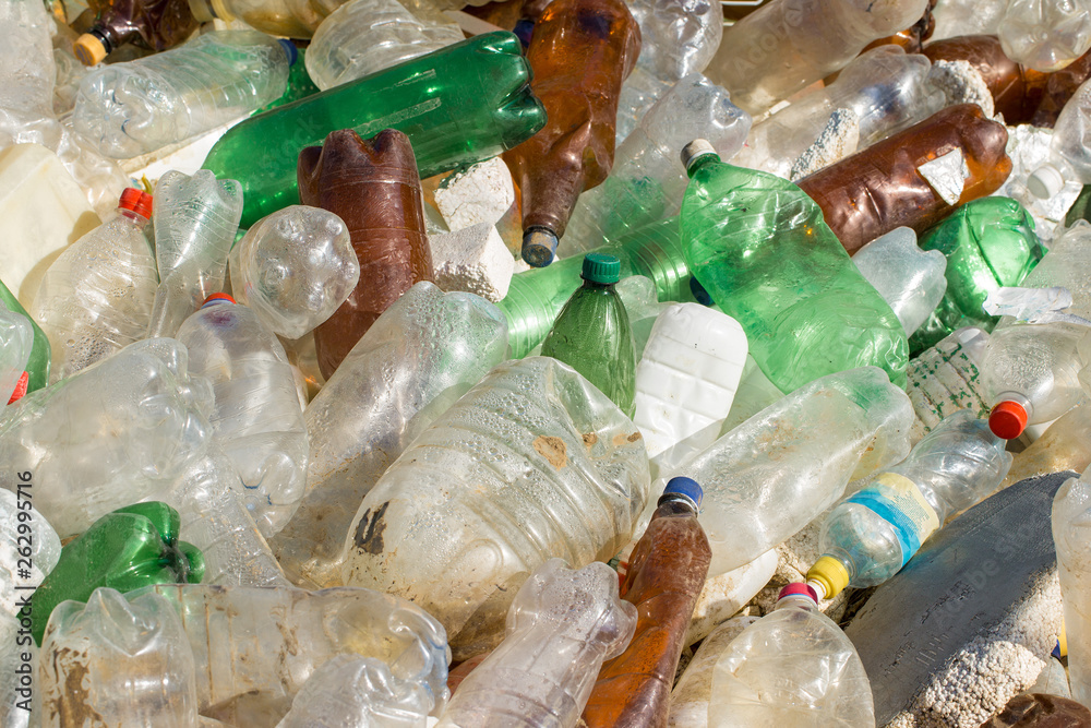 Plastic bags and bottles in a landfill. Unauthorized release of garbage, pollution of nature. The concept of environmental disaster. Plastic bags and bottles in a landfill. Unauthorized release of garbage, pollution of nature. The concept of environmental disaster.