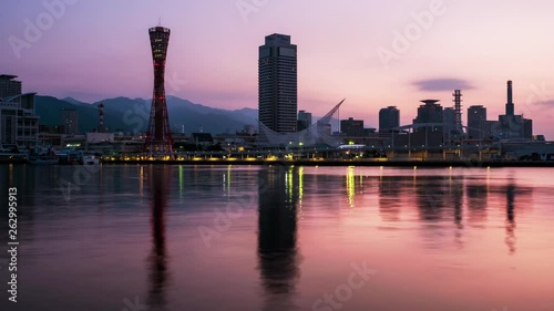 Kobe, Japan. View of sunrise in Kobe, Japan. Time-lapse of cloudless sky with harbor and numerous skyscrapers and Port Tower