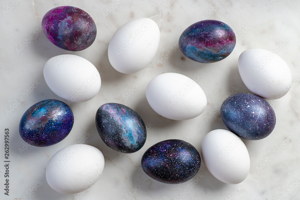 Easter eggs with cosmic pattern and white Easter eggs on the marble surface Easter eggs with cosmic pattern and white Easter eggs on the marble surface