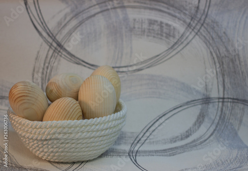 Decorative wooden Easter eggs in a wicker plate basket
