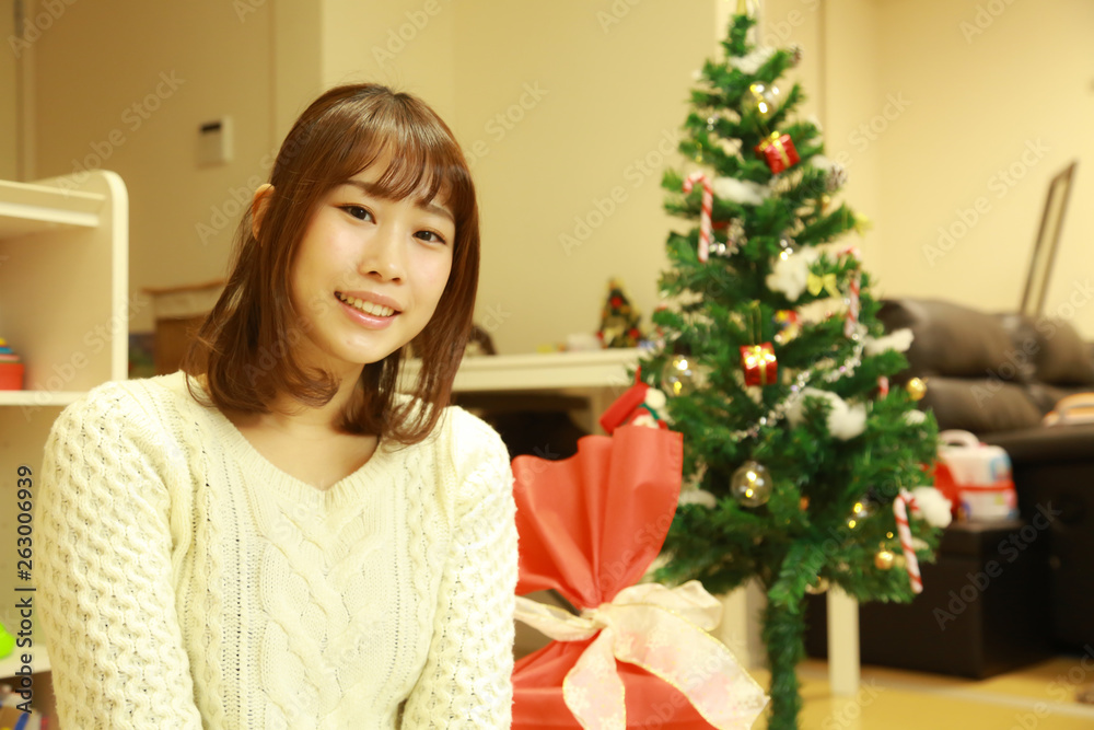 クリスマスツリーの飾りをつける女性 クリスマスツリーの飾りをつける女性