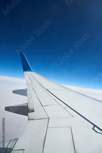 View from a landing airplane out the window travel. Wing of an airplane flying above the clouds over tropical island Turkey. Wing of airplane flying above the clouds in the sky
