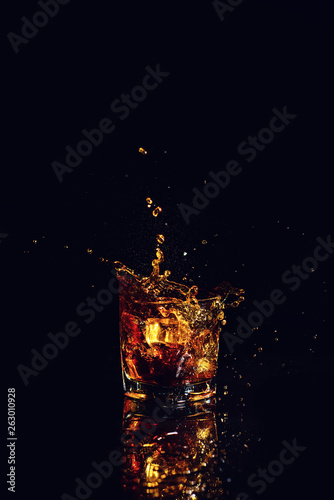 shot of whiskey with splash on black background
