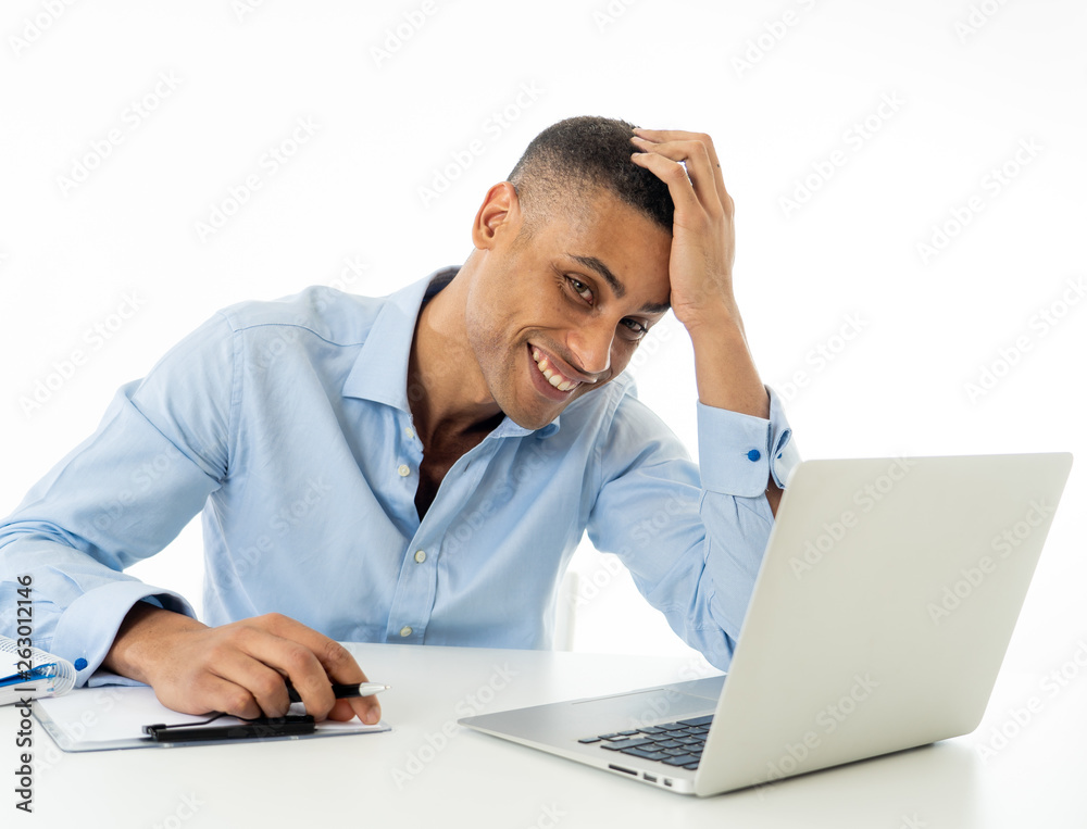 Attractive happy handsome african american businessman working on laptop computer on desk at office Attractive happy handsome african american businessman working on laptop computer on desk at office