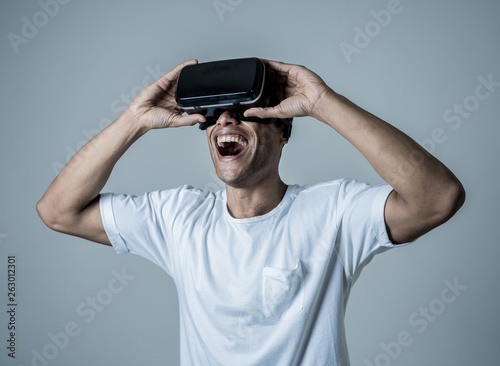 Portrait of cheerful and shocked young man wearing Virtual Reality headset exploring 3D world © SB Arts Media