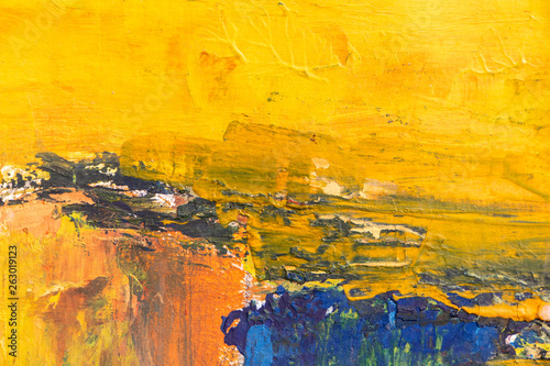 Texture of bright strokes of cracked yellow and blue paint on the wall surface. Empty background.