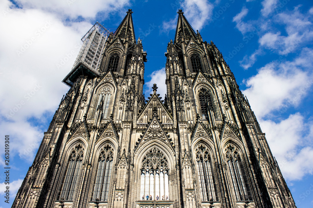 Mighty huge and high Cologne Dome in the blue sky. Famous German ancient cathedral in the center of Cologne.