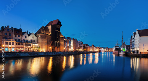 Old town in Gdansk, Poland at night. Riverside with the famous Crane and city reflections in the Motlava river. High resolution panorama.
