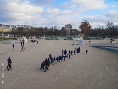 Paris 20 December 2018. Tuileries park. There is a group of children with a teacher.  Tourists go. bright day