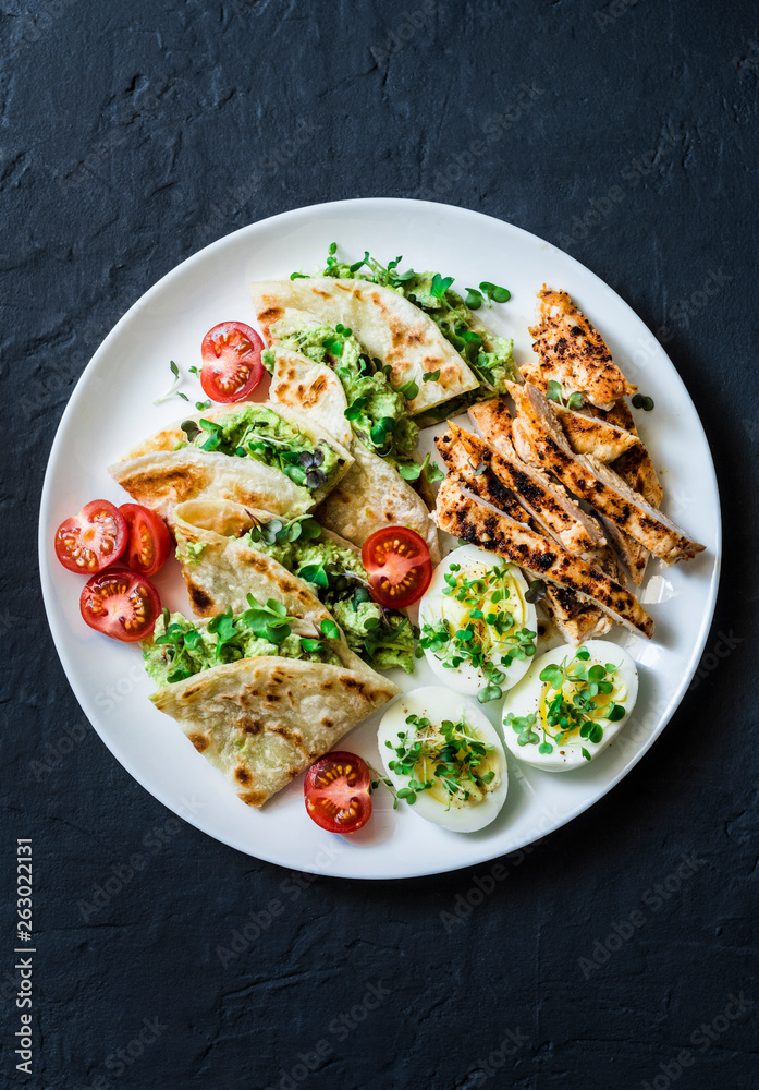 Large tapas plate - grilled, chicken, avocado cream cheese quesadilla,  boiled eggs, vegetables - tasty snack on a dark background, top view Stock  Photo | Adobe Stock