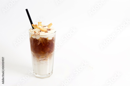 Glass of cold coffee drink with whipped cream, syrup and cookies on white background. Beverages, menu concept. Close-up, copy space, layout design